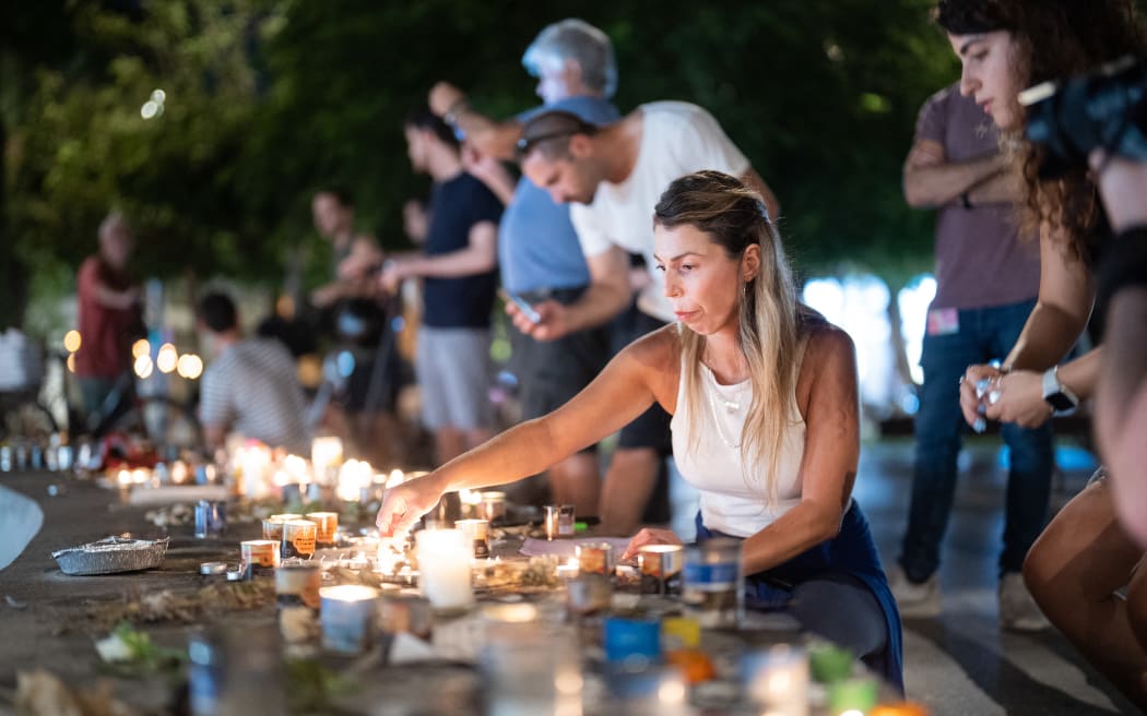 People gather and light candles to remember the victims who were murdered by Hamas militants at Dizengoff Square in Tel Aviv, 22 October, 2023 (Photo by Dima Vazinovich / Middle East Images / Middle East Images via AFP)