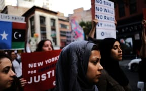 Recent Immingrants join activists for an evening protest in Manhattan in the hours before the revised version of President Donald Trump's travel ban came into effect.
