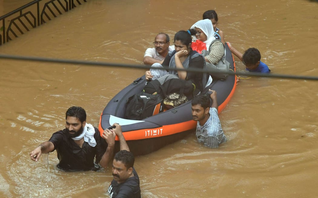 Rescuers wade through the water at Companypady in kozhikode, Kerala