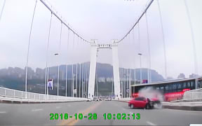 In this screen shot, a bus crashed with a car and plunged into the Yangtze River from a bridge in Wanzhou district