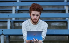 A shot of Henry Cooke holding an iPad