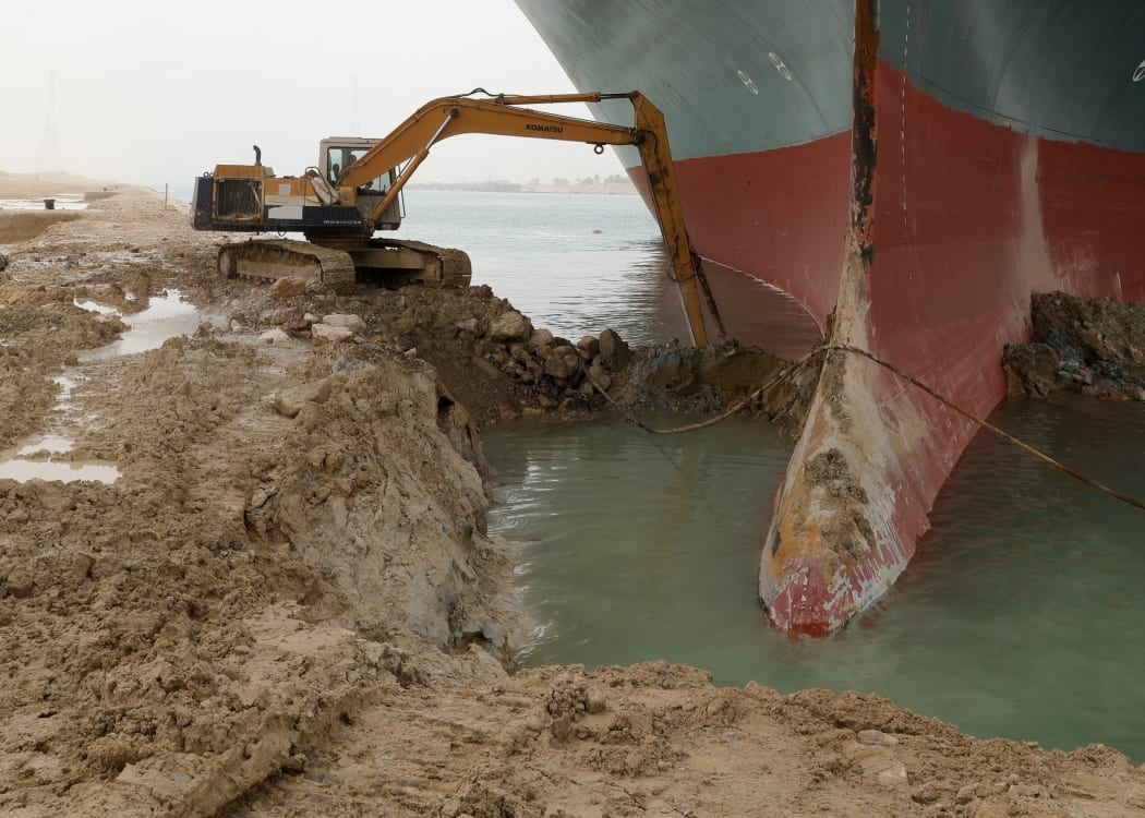 An excavator attempts to free the front end of the Ever Given container ship that ran aground in the Suez Canal, Egypt in March 2021.
