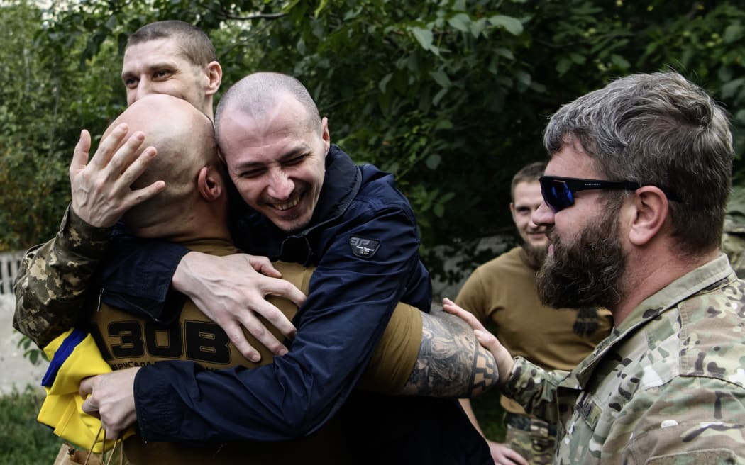 A fellow soldier hugs a Ukrainian prisoner of war (POW) who returns from captivity as forty-nine civilian and military Ukrainians return to Ukraine after a swap with Russia in Chernihiv Region, Ukraine, on September 13, 2024. (Photo by Maxym Marusenko/NurPhoto) (Photo by Maxym Marusenko / NurPhoto / NurPhoto via AFP)
