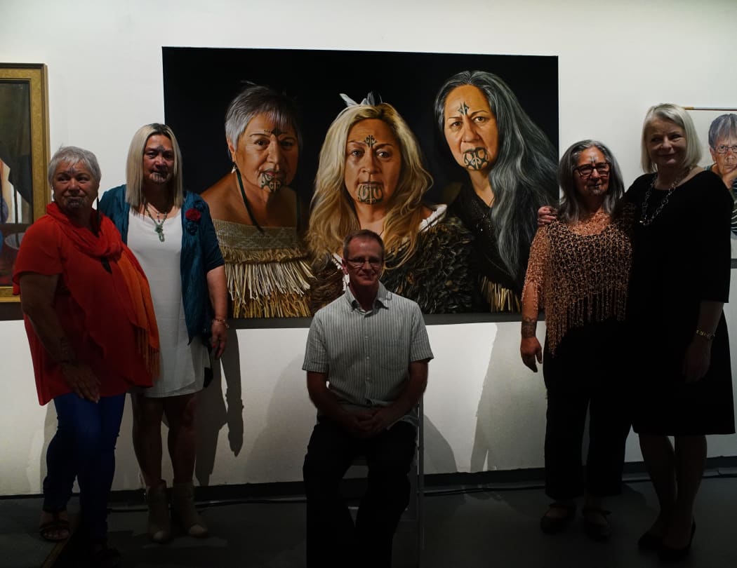 Te Rawanake Robinson-Coles, Inahaa Te Urutahi Waikerepuru, Andre Bronnimann, Ria Wihapi-Waikerepuru and Mette Skougaard stand in front of 'Sisters' at the Adam Portraiture Awards in Wellington.