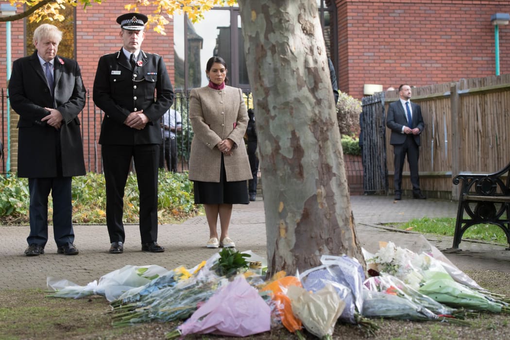 Britain's Prime Minister Boris Johnson, left, stands with with Chief Constable of Essex Police, Ben-Julian Harrington and UK Home Secretary Priti Patel after they laid flowers to pay their respects to the victims.