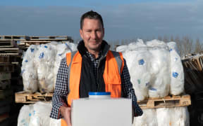 Green Valley Dairies general manager Mark Pulman holds a refillable milk keg. He says farmers are getting on board with being more environmentally conscious.