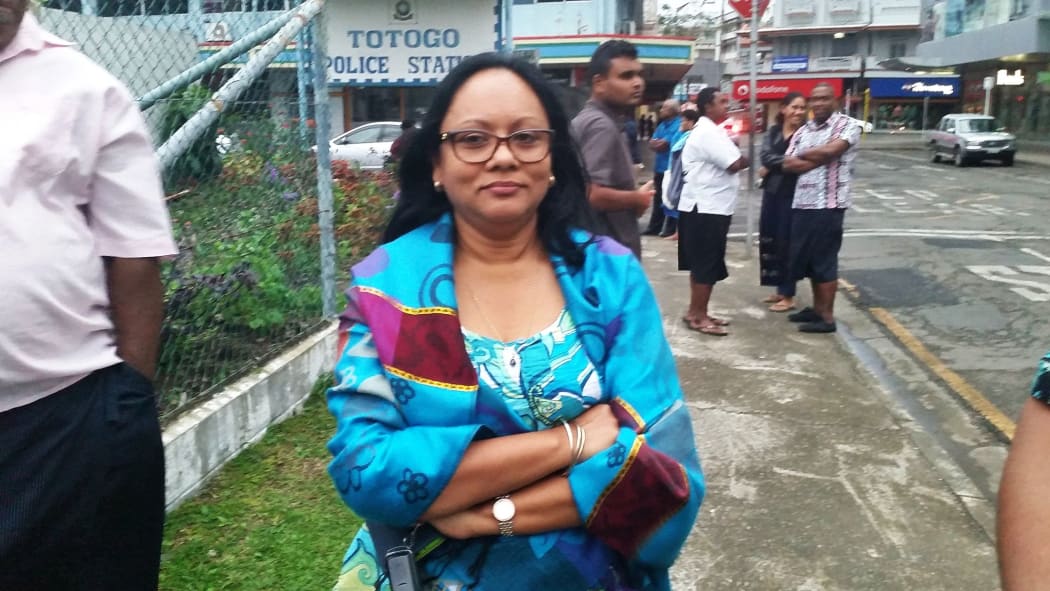Biman Prasad's wife Rajni waits outside the police station to take her husband dinner and clothes.