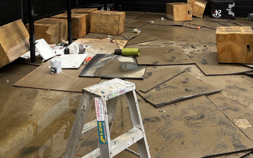 Mud is seen inside the gym and on equipment following flooding.