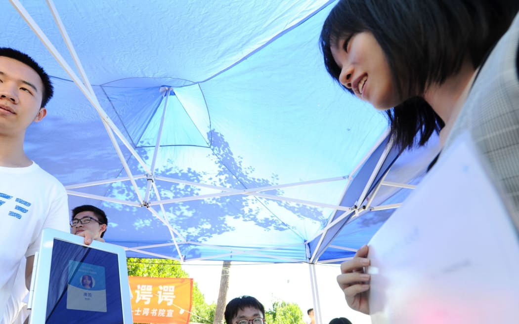 A freshman scans her face to register through a facial recognition system on the ipads at the campus of the Beihang University in Beijing, China, 29 August 2018.
