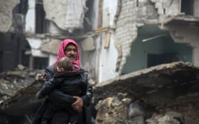 A Syrian man and child leave a rebel-held area of Aleppo.