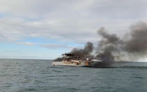 The ship ablaze in Mercury Bay.
