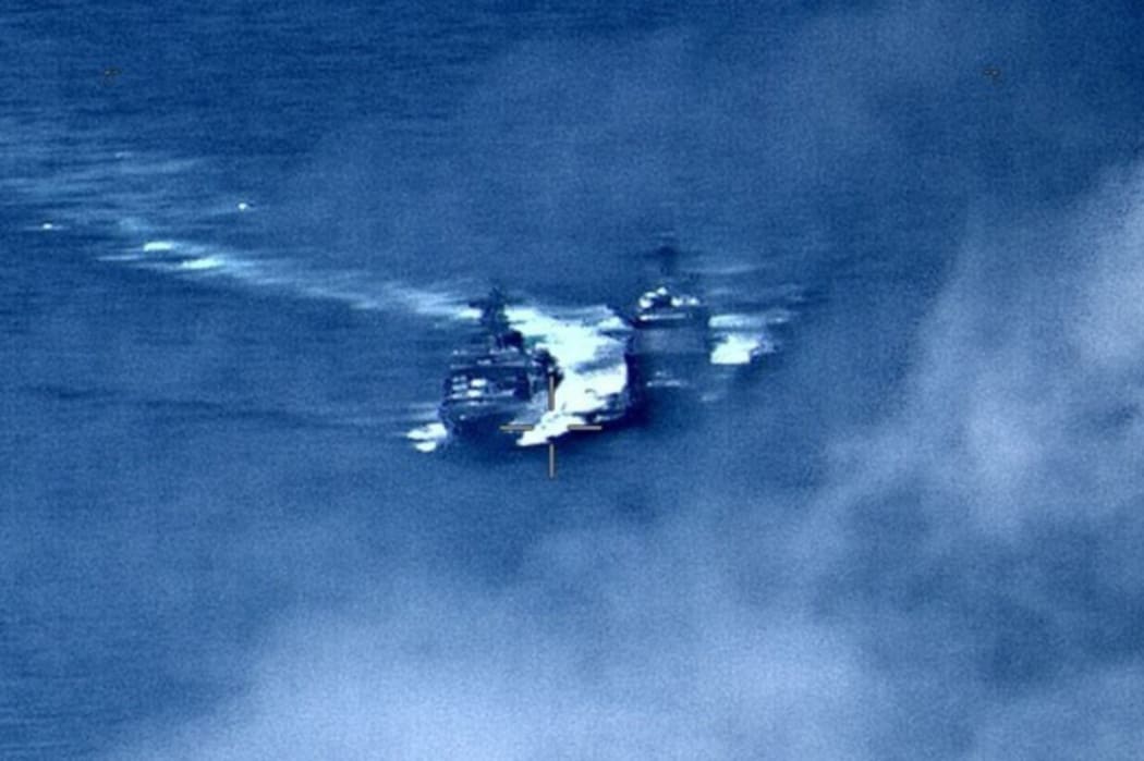 In this image provided by the U.S. Navy, a Russian destroyer, left, sails very close to the USS Chancellorsville, right, while operating in the Philippine Sea, Friday, June 7, 2019.