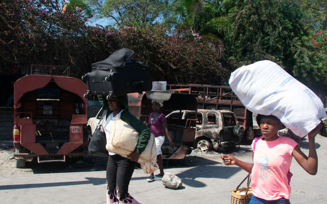 People are seen carrying their belongings as they leave the city that has become too unsafe after gang violence, in Port-au-Prince, Haiti, March 5, 2024. Haiti's police academy came under attack by an armed gang on March 5, as the tiny Caribbean nation fell into deeper isolation in the wake of an assault on the airport and a deadly prison breakout.
Gang leaders such as Jimmy Cherisier, known by the nickname Barbecue, say they are coordinating to oust Prime Minister Henry, who has led the troubled Caribbean nation since the assassination of president Jovenel Moise in 2021. (Photo by Clarens SIFFROY / AFP)