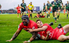 Toulouse's Pita Ahki celebrates scoring a try with Antoine Dupont.