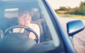 Upset woman sitting in the car and covering face with her hands. Concept of a accident and traffic violations.