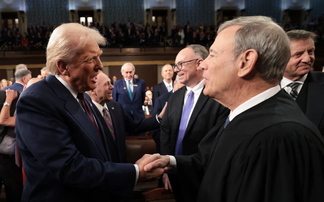 US President Donald Trump (L) greets Chief Justice of the United States John Roberts as he arrives to deliver an address to a joint session of Congress at the US Capitol in Washington, DC, on March 4, 2025. (Photo by Win McNamee / POOL / AFP)