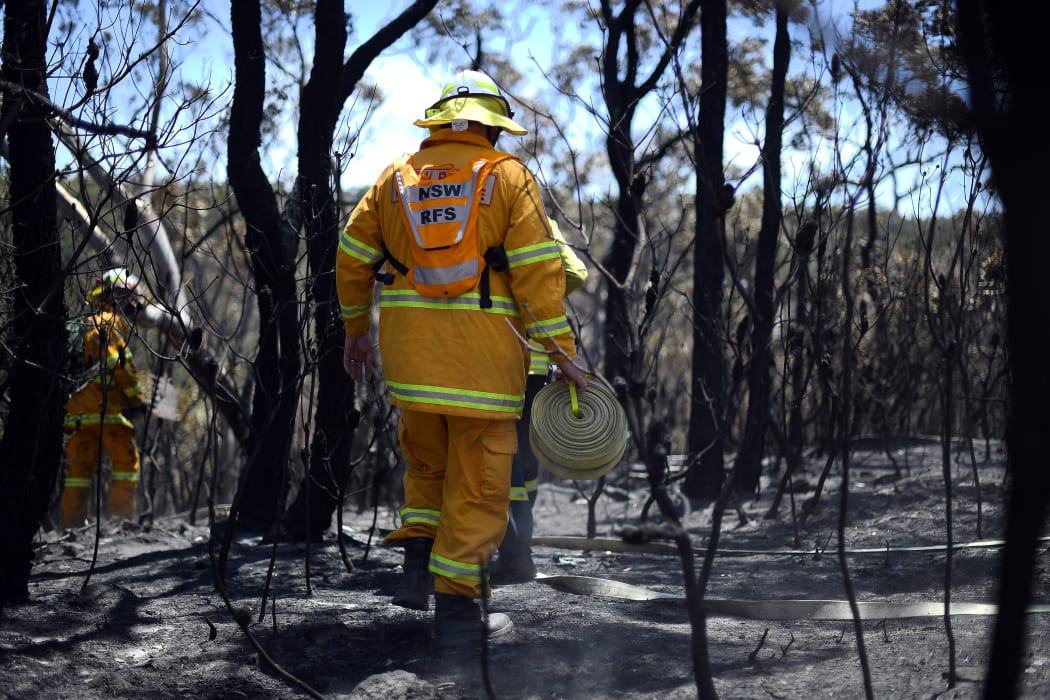 Firefighters monitor bush fires at the Woodford residential area in Blue Mountains on November 12, 2019