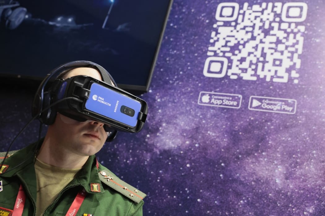 A serviceman wearing virtual reality glasses watches the presentation of RIA Lab VR projects at a stall of Rossiya Segodnya International Information Agency during the Army-2021 International military-technical forum in the Patriot Park in Kubinka, Moscow.