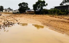 Some of the residential roads in Ōakura remain covered in thick mud.