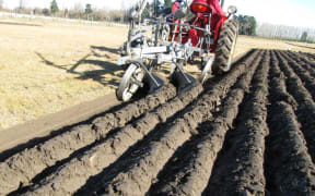 A tractor ploughing the ground.