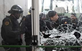Spanish Guardia Civil guards brake the door of a polling station in Sant Julia de Ramis.