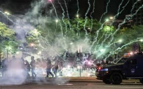 Tear gas canisters explode near some Detroit Police units who attempted to break up protesters, through the streets of Detroit, Michigan for a second night.