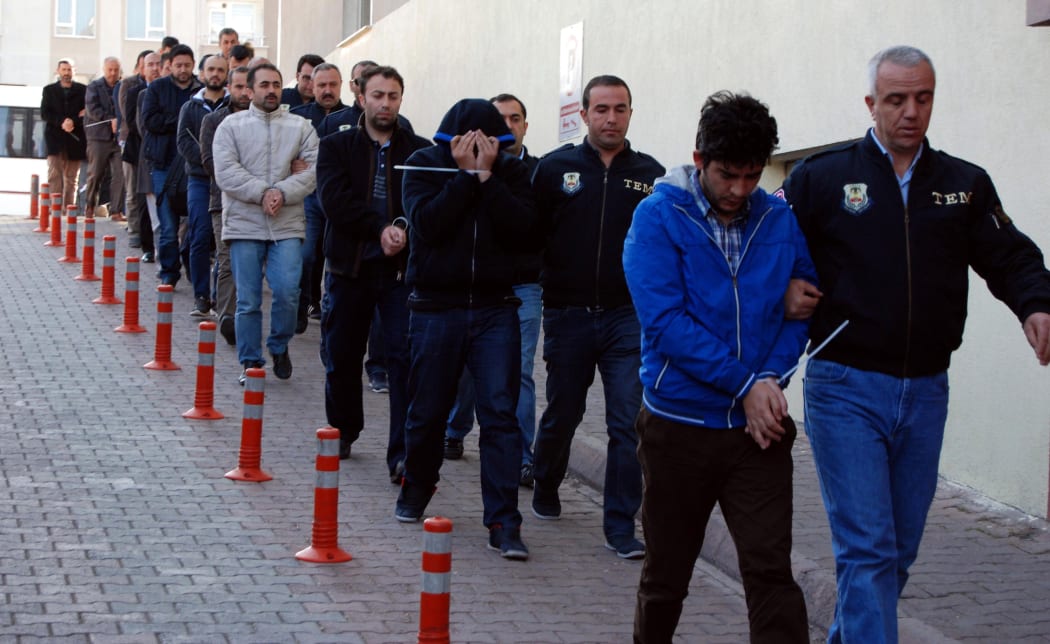 Turkish police officers escort people arrested in the central city of Kayseri for alleged links with Muslim cleric Fethullah Gulen.