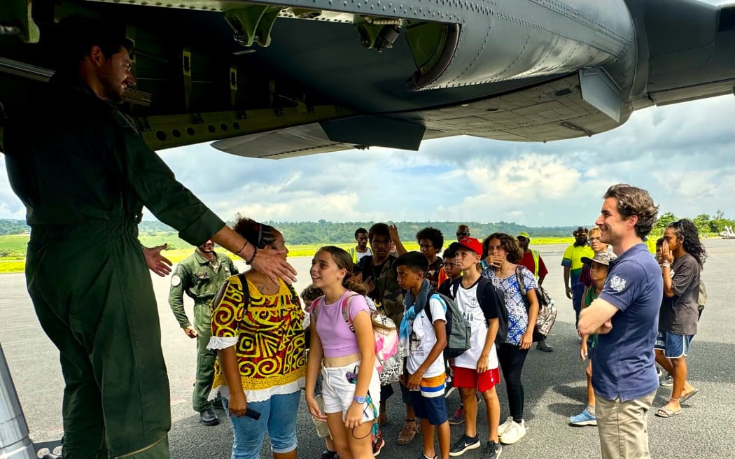 A group of schoolchildren boarding a military aircraft to be repatriated to New Caledonia after the Vanuatu earthquake.