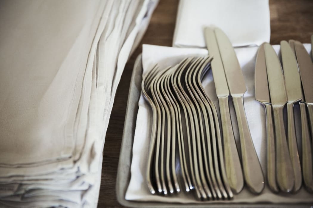 [England] High angle close up of napkins and silver forks and knives on a table in a restaurant. (Photo by Mint Images / Mint Images / Mint Images via AFP)