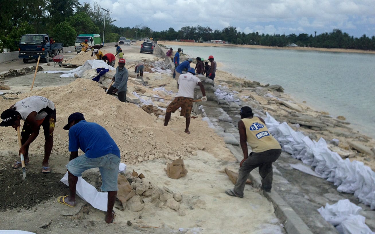 Sand bagging the beach to stop erosion in Tarawa, Kiribati.