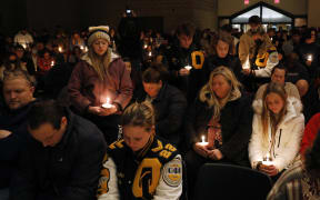 Oxford High students stand holding candles during a vigil after a shooting at Oxford High School at Lake Pointe Community Church in Lake Orion, Michigan.