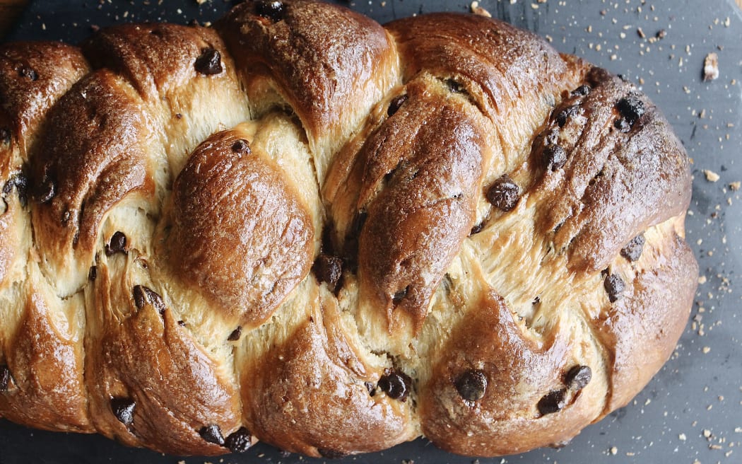 Landscape image of a chocolate studded loaf of braided challah.