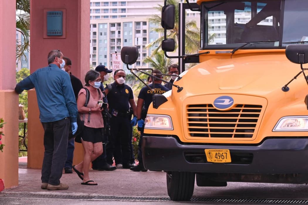 Some of the people who are under quarantine at Hotel Santa Fe Guam in Tamuning board a bus to be moved to a new location. Monday 23 March.