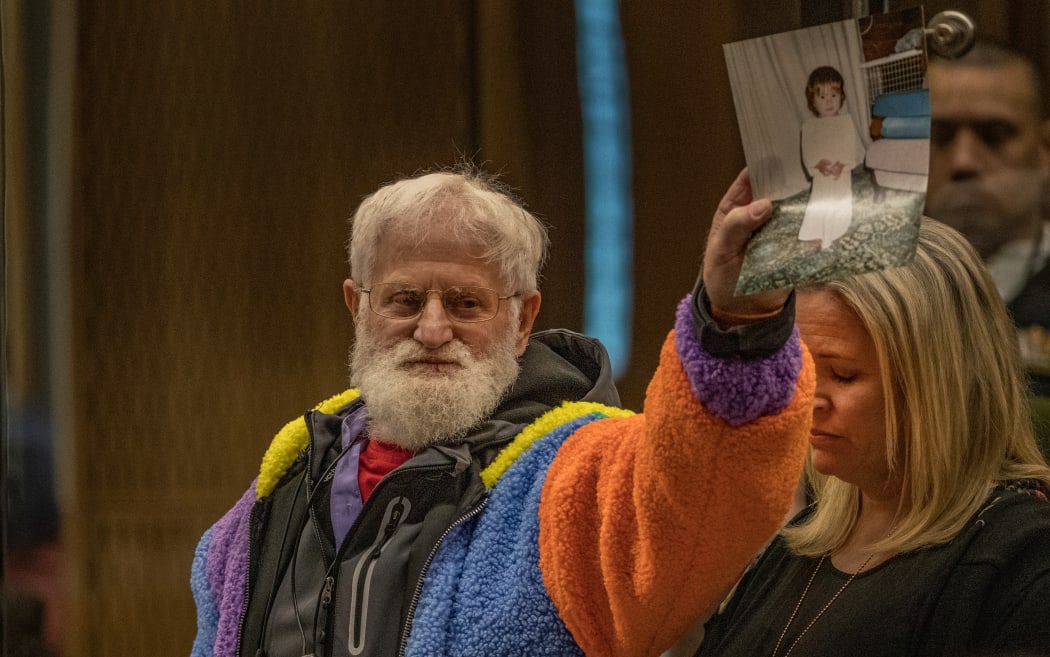John Milne holds a photograph of his son, Sayyad Milne, who was killed -  - victim impact statement. His daughter, Brydie Henry, right.

PHOTO: JOHN KIRK-ANDERSON

Sentencing for Brenton Tarrant on 51 murder, 40 attempted murder and one terrorism charge.