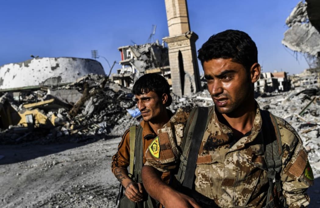 Members of the Syrian Democratic Forces (SDF), backed by US special forces, check the area near Raqqa's stadium.