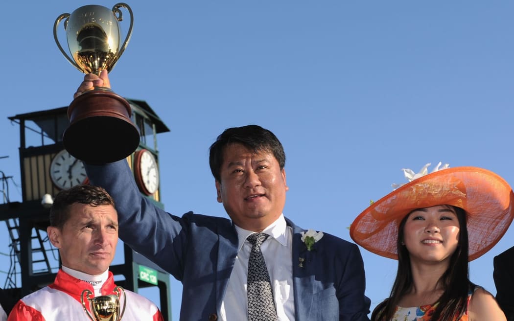 Winning owner Lin Lang poses with trophy with jockey Opie Bosson.