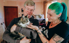 Thomas with his owner Alan Aaltonen and  Loose Leash Cat Rescue organiser Emjay Dette.