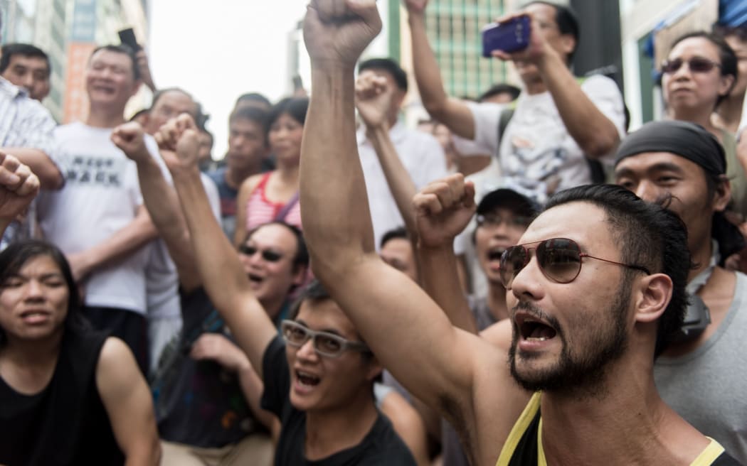 Pro-democracy protestors cheer in an effort to calm a man shouting slogans at them in the Mong Kok district.