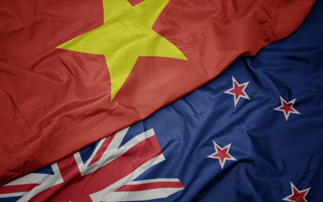waving colorful flag of new zealand and national flag of vietnam. macro