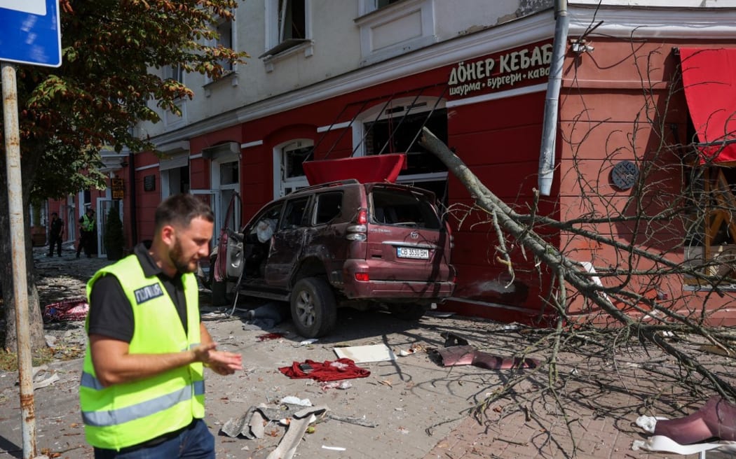 A police officer inspects the site of a missile strike in the centre of Chernihiv, on August 19, 2023. A Russian missile strike on Ukraine's northern city of Chernihiv killed at least five people and wounded dozens.