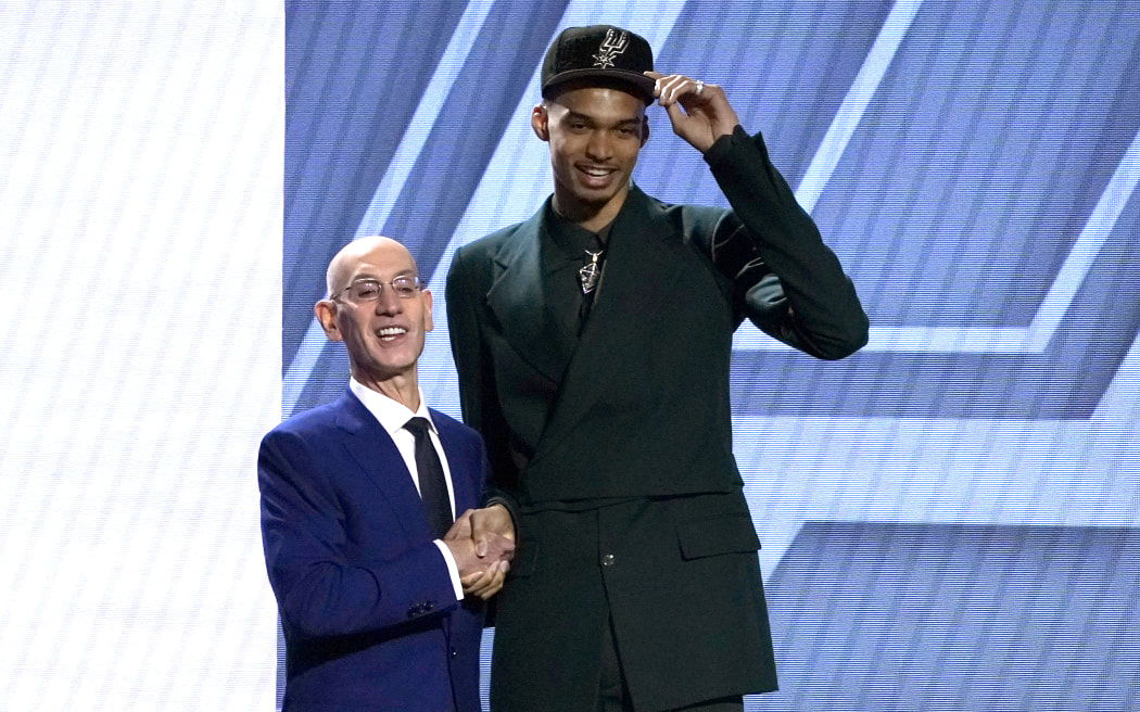 French basketball player Victor Wembanyama (right) shakes hands with NBA commissioner Adam Silver after being picked by the San Antonio Spurs during the NBA Draft in New York.