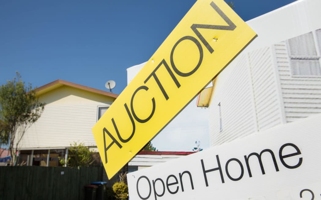 An auction sign outside a house for sale in Auckland.