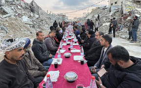 Palestinians gather for a communal iftar, or fast-breaking meal, on the first day of the Muslim holy month of Ramadan, amid building rubble in Rafah in the southern Gaza Strip on March 1, 2025. (Photo by AFP)