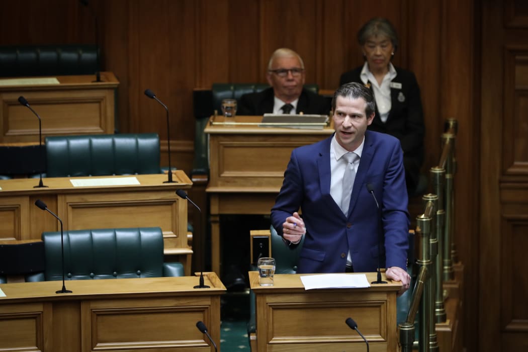 Chris Penk speaks on End of Life Choice. Behind him are two of Parliament's chamber staff.
