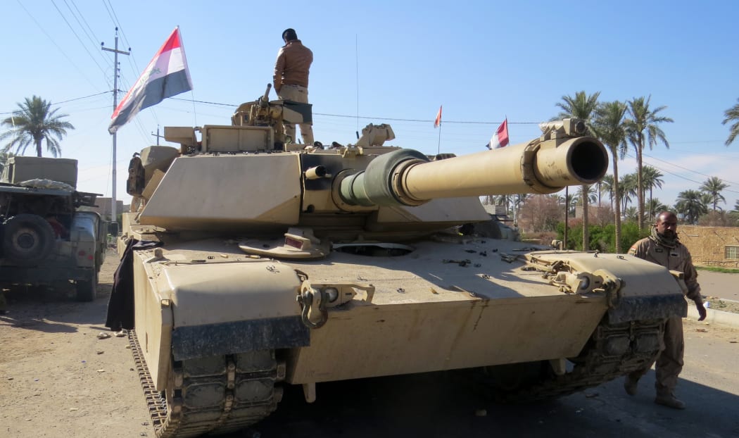 Iraqi security forces stand next to a tank as they clear al-Sajarya district on the eastern outskirts of Ramadi, the capital of Anbar province.