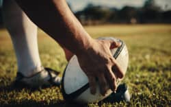 Cropped shot of an unrecognisable rugby player preparing for a kick on the field during the day