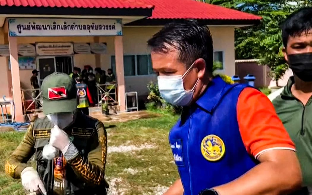 Officials outside a nursery in the northern Thai province of Nong Bua Lam Phu, where a former policeman shot dead at least 30 people in a mass shooting.