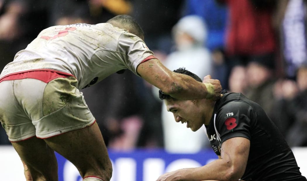Kiwis fullback Roger Tuivasa-Sheck is comforted by an England player after losing the Test series decider at Wigan