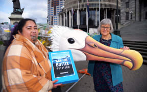 Juressa Less presents the 'ban the bottle' petition to MP Eugenie Sage, with 'Birdy' the Toroa sculpture, made of single-use plastic bottles.