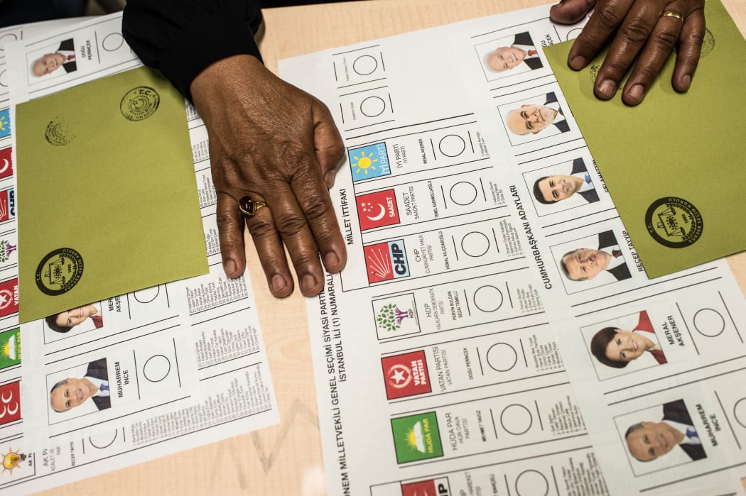 Ballot papers are laid on a table at a polling station as people arrive to vote in snap twin Turkish presidential and parliamentary elections in Istanbul.